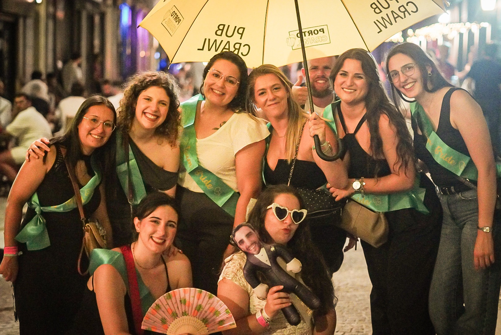 Private group celebrating under a yellow Porto Crawl umbrella